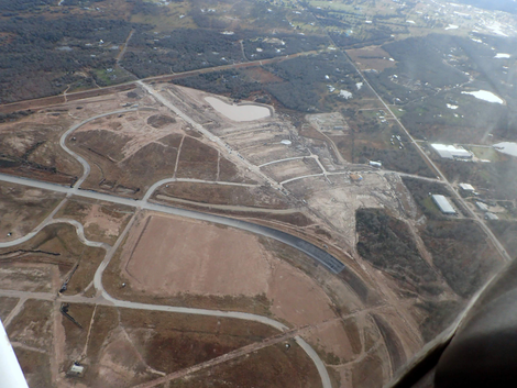 The two houses can be seen at the end of the street closest to the track, next to each other.